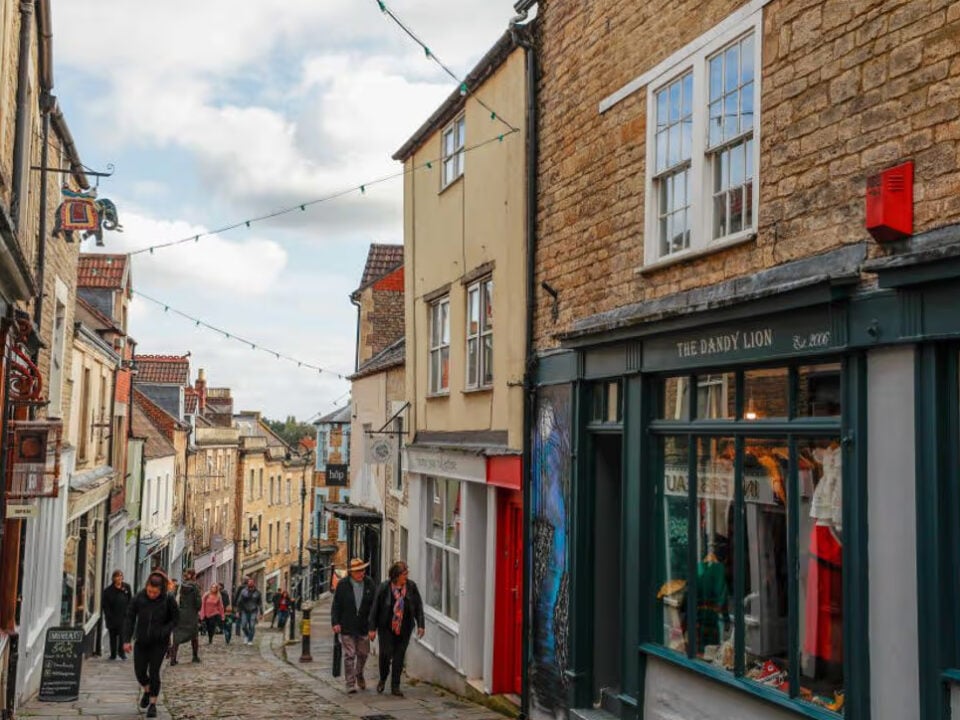 Narrow street lined with shops and pedestrians