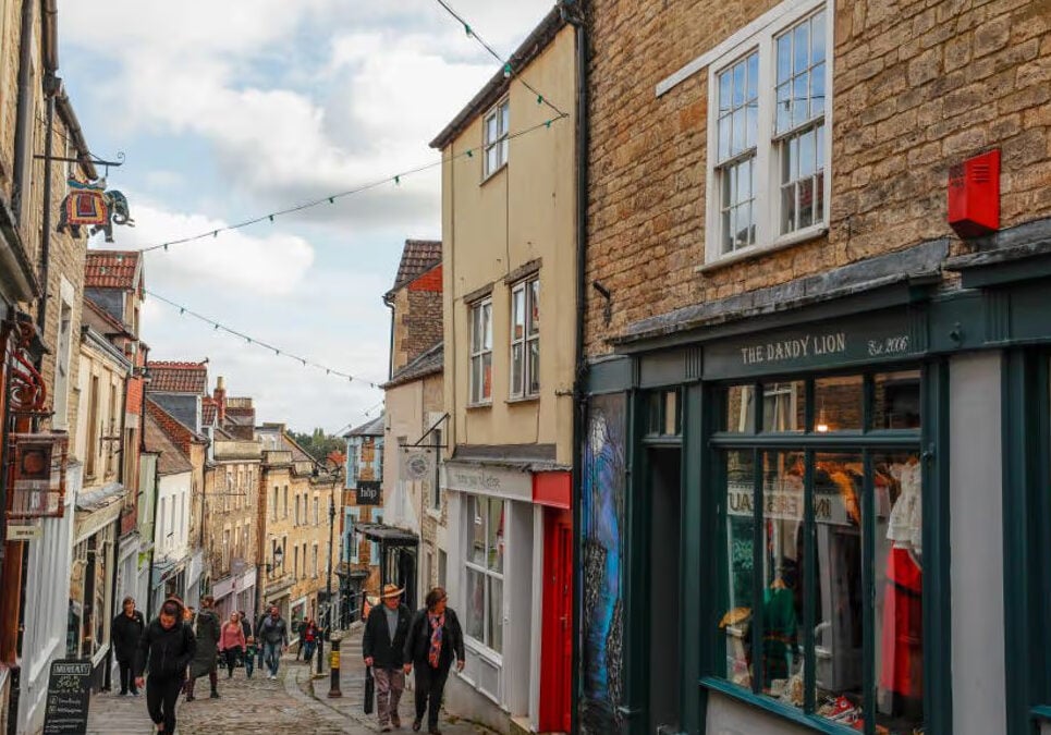 Narrow street lined with shops and pedestrians