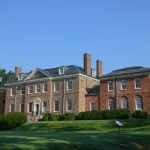 Brick Georgian-style mansion with a wide front lawn